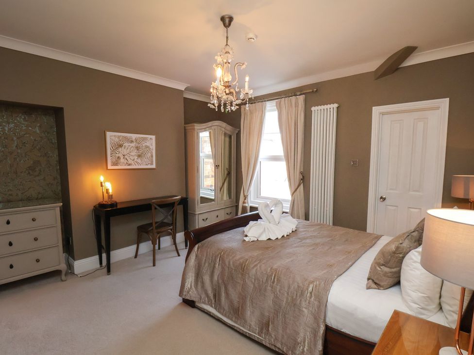 A bedroom with a bed, dresser, and chair at 11 Rutland Street in Filey