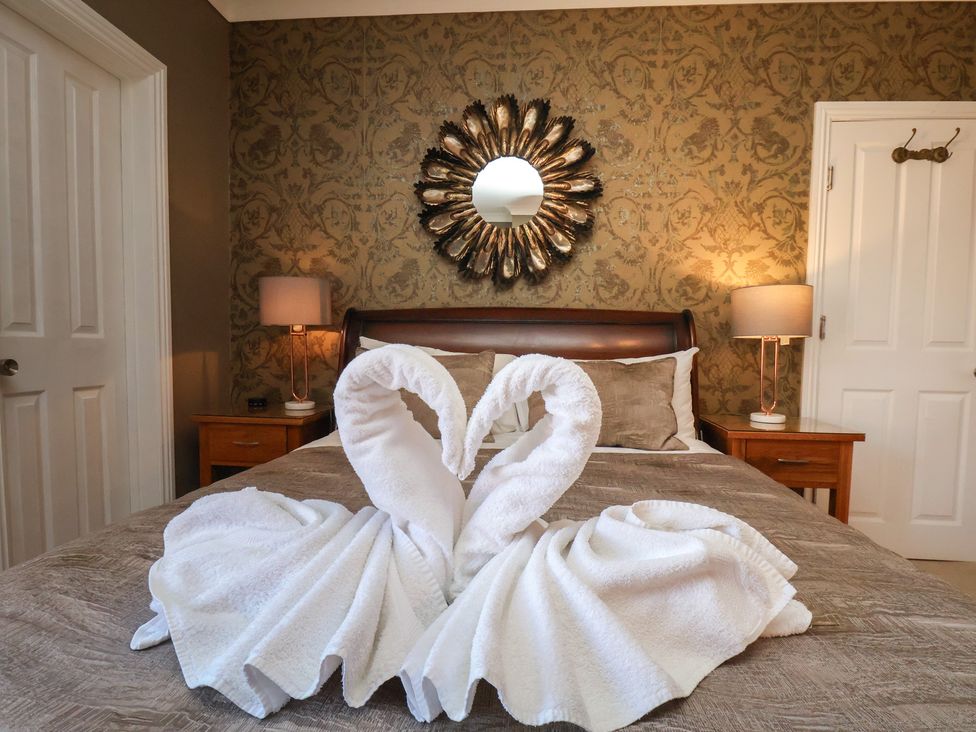 A bedroom with towel swans on the bed at 11 Rutland Street in Filey