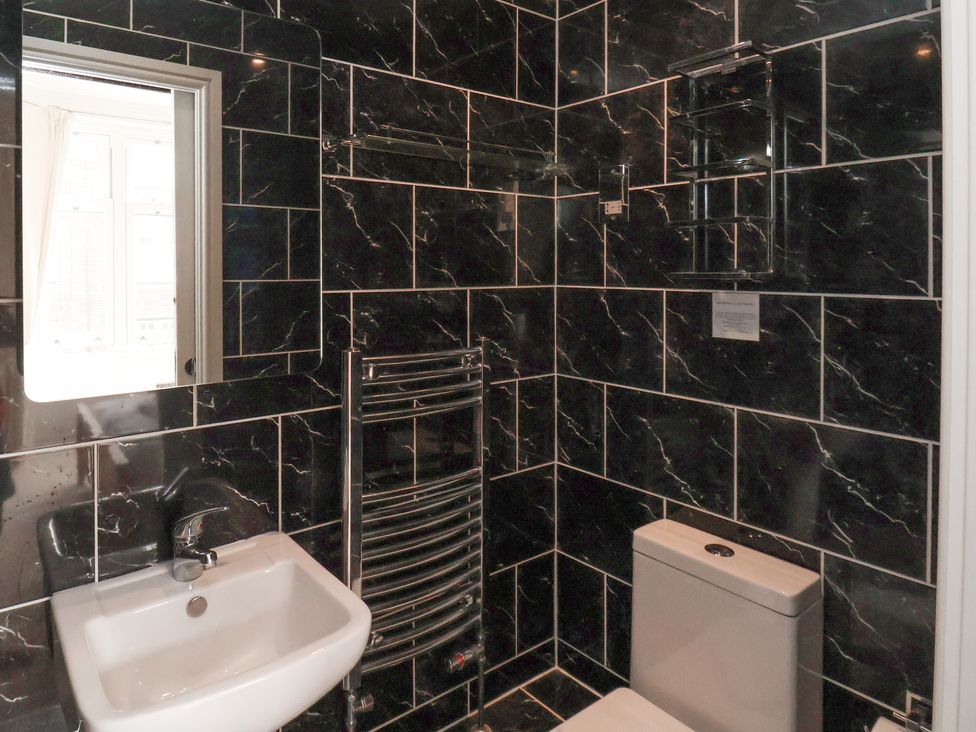 A bathroom with sink, toilet, and radiator at 11 Rutland Street Filey