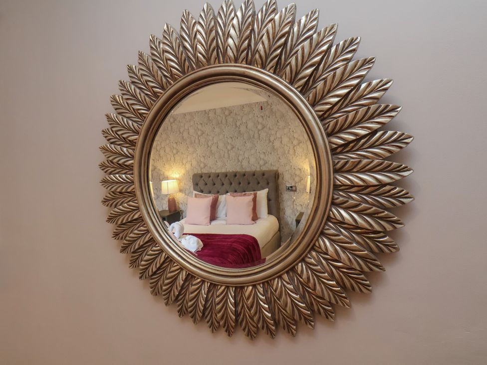 A mirror reflecting a bedroom setting at 11 Rutland Street in Filey