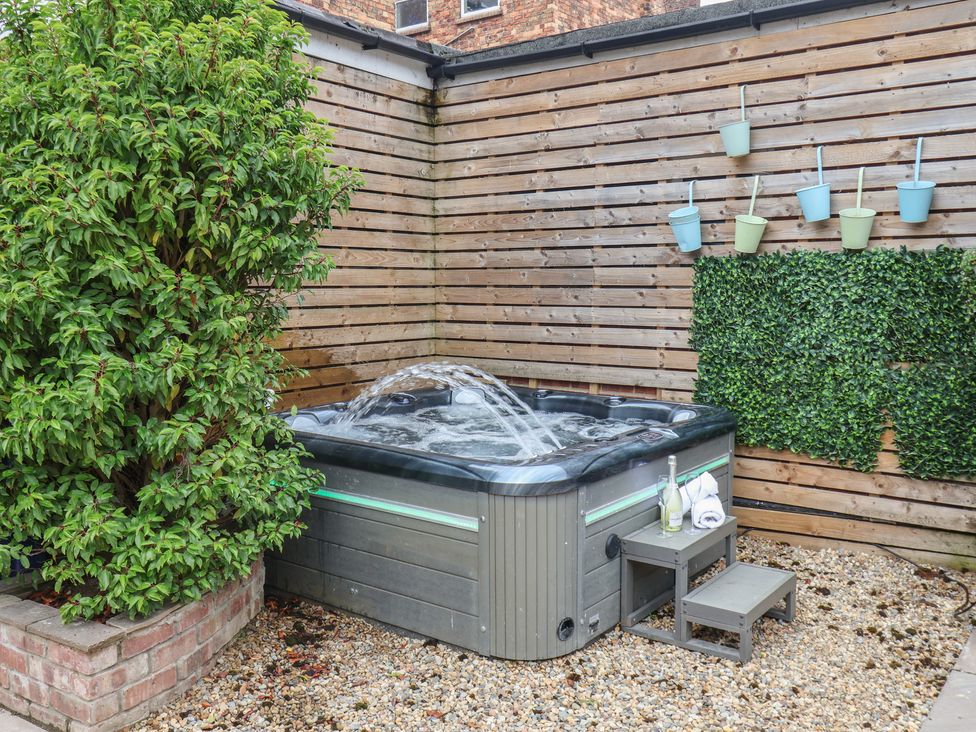 A garden with a hot tub and decorative planters at 11 Rutland Street Filey