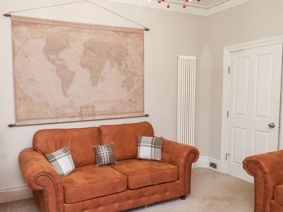 A living room with a sofa and a world map at All Seasons in Filey