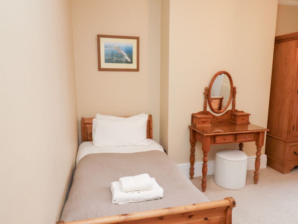 A bedroom with a bed and vanity at All Seasons in Filey