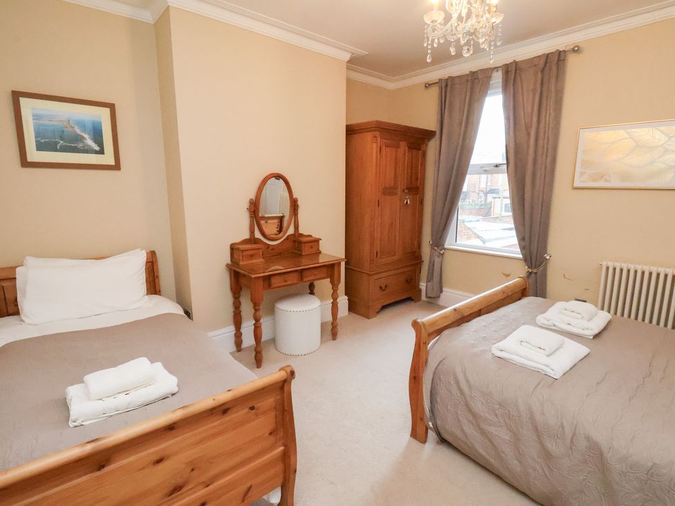 A bedroom with two beds and a wardrobe at All Seasons in Filey