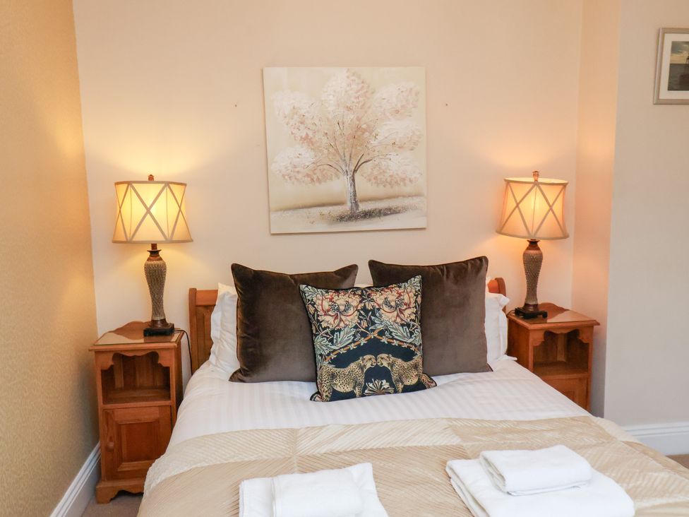 A bedroom with a bed and lamps at All Seasons in Filey