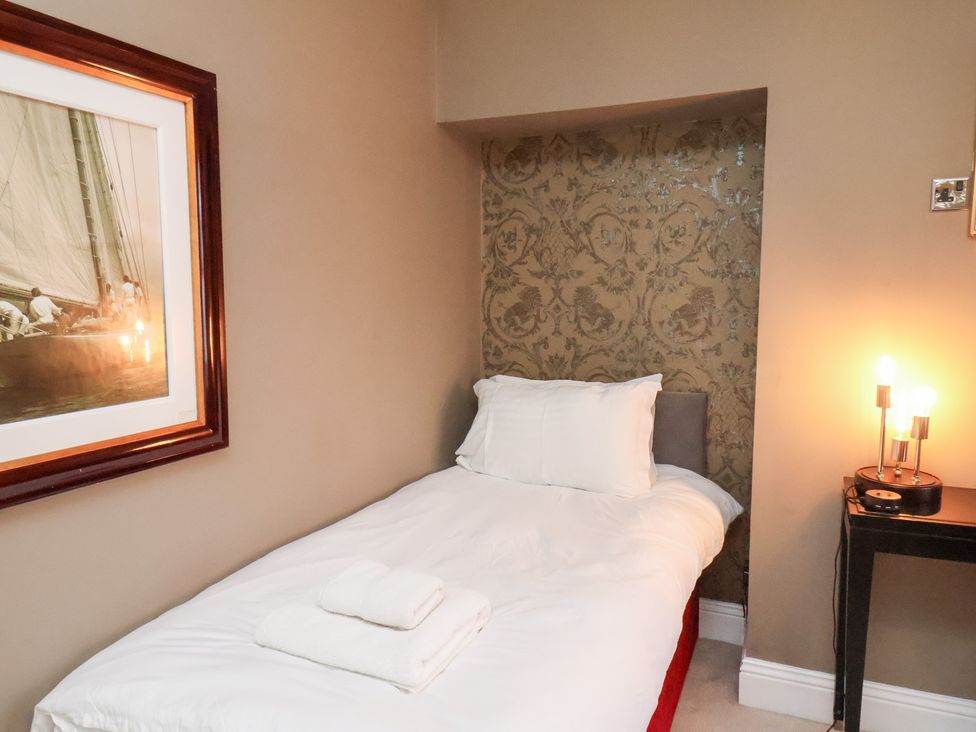 A bedroom with a single bed and nightstand at All Seasons in Filey
