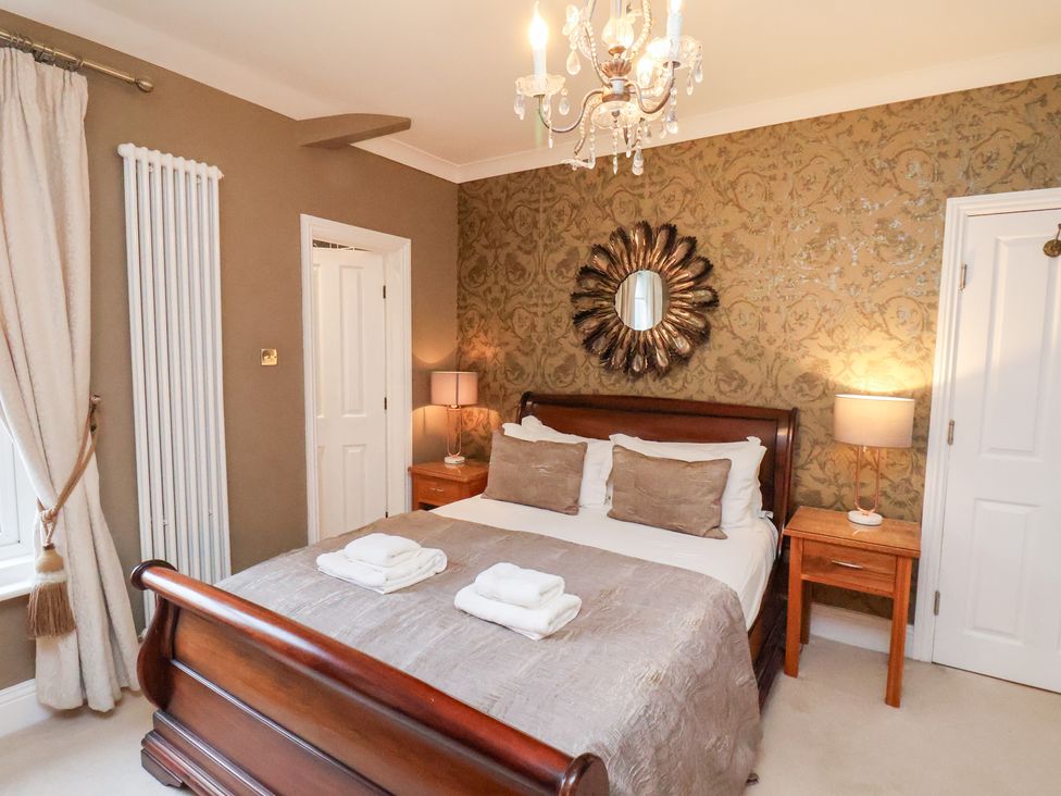 A bedroom with a bed and nightstands at All Seasons in Filey