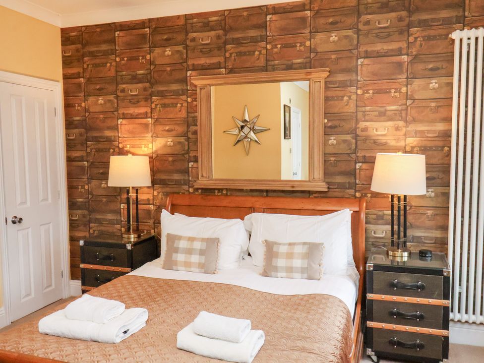 A bedroom with a bed and nightstands at All Seasons in Filey