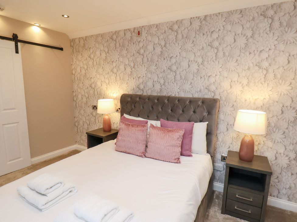 A bedroom with a bed and bedside tables at All Seasons in Filey