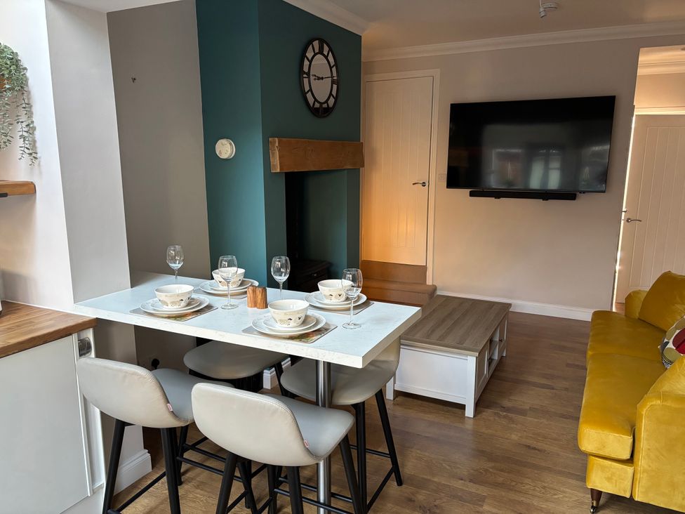 A dining area with a table set for four and a sofa at 97 Mayfield Road Ashbourne