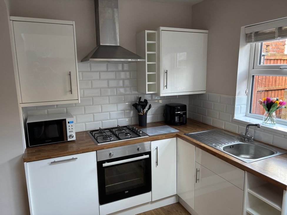 A kitchen with a gas stove and microwave at 97 Mayfield Road in Ashbourne