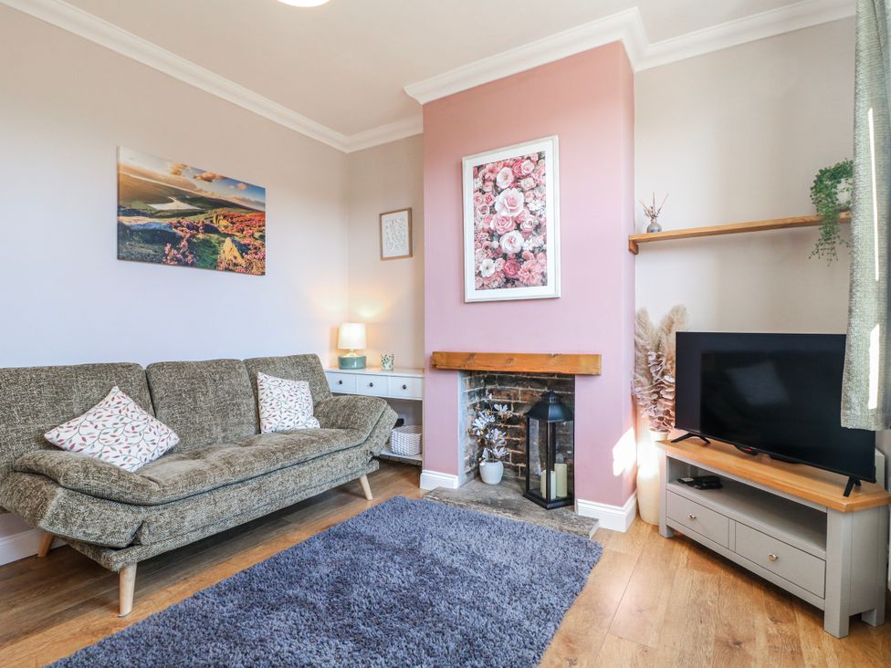 A living room with a sofa and television at Hill View Cottage in Ashbourne
