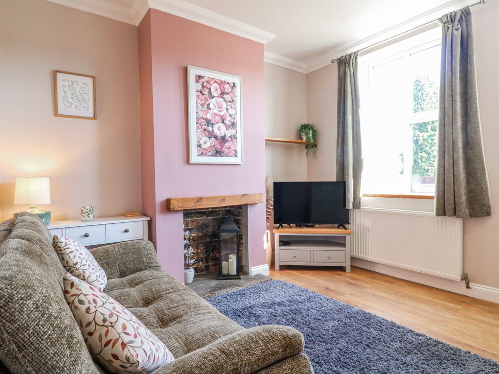 A living room with a TV and a sofa at Hill View Cottage in Ashbourne