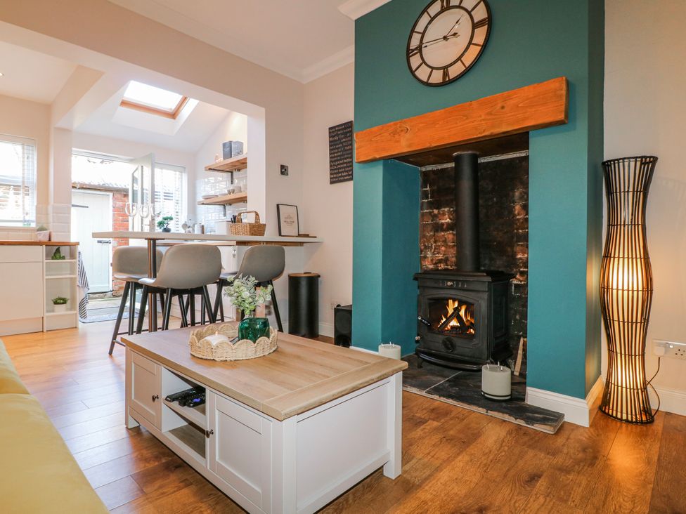 A living room with a fireplace and table at Hill View Cottage in Ashbourne