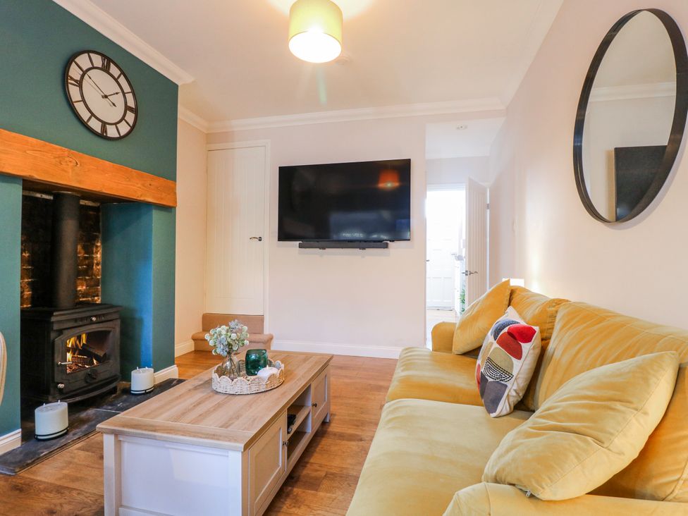 A living room with a sofa and television at Hill View Cottage in Ashbourne