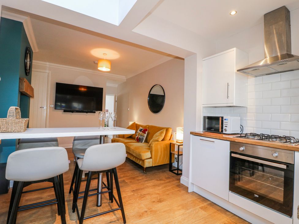 A kitchen with a sofa and TV at Hill View Cottage in Ashbourne