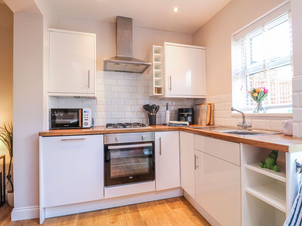 A kitchen with an oven, sink, and microwave at Hill View Cottage Ashbourne