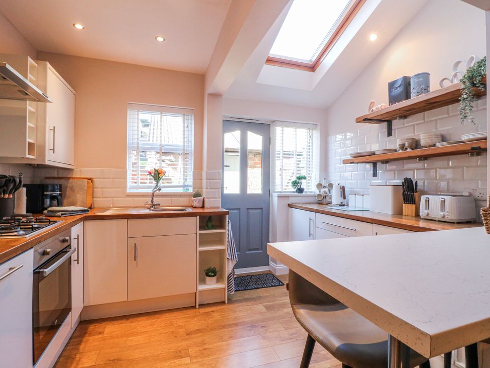 A kitchen with countertops and shelves at Hill View Cottage Ashbourne