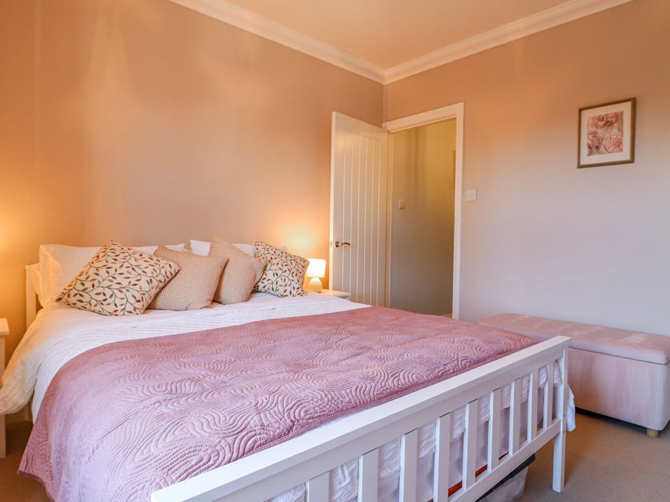 A bedroom with a bed and two lamps at Hill View Cottage in Ashbourne