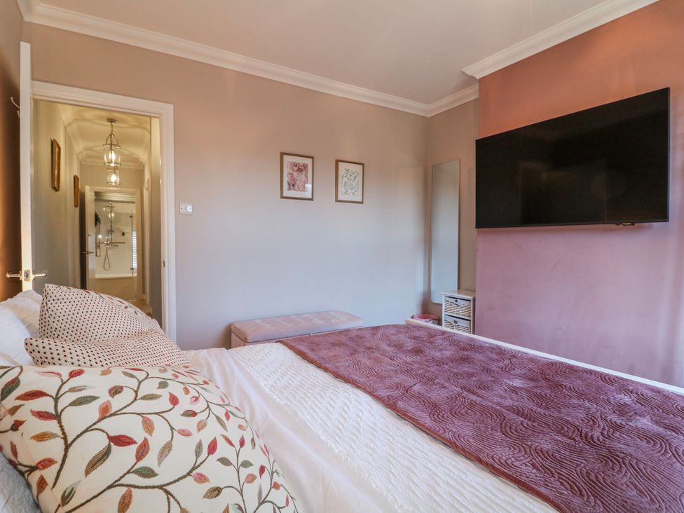 A bedroom with a bed and TV at Hill View Cottage Ashbourne