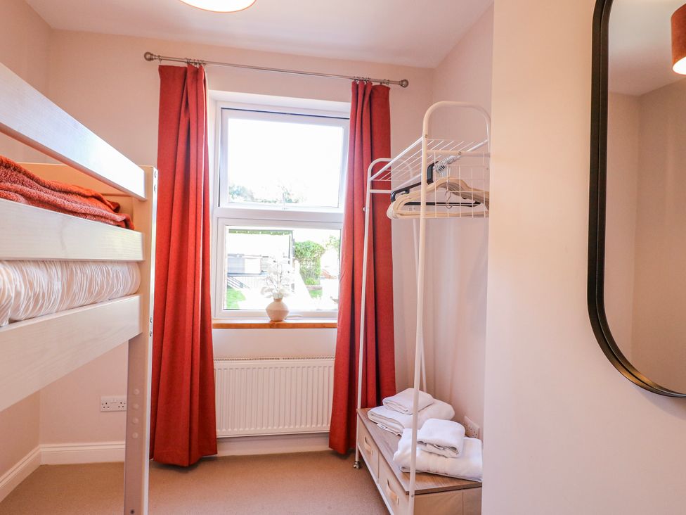 A bedroom with a bunk bed and a window at Hill View Cottage in Ashbourne