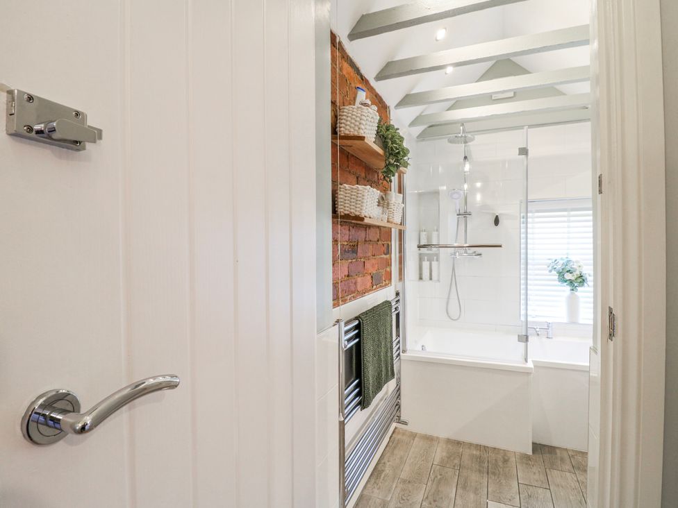 A bathroom with a shower and bathtub at Hill View Cottage in Ashbourne