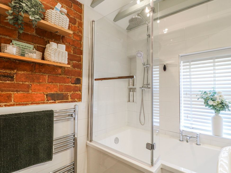 A bathroom featuring a shower over a bathtub at Hill View Cottage Ashbourne