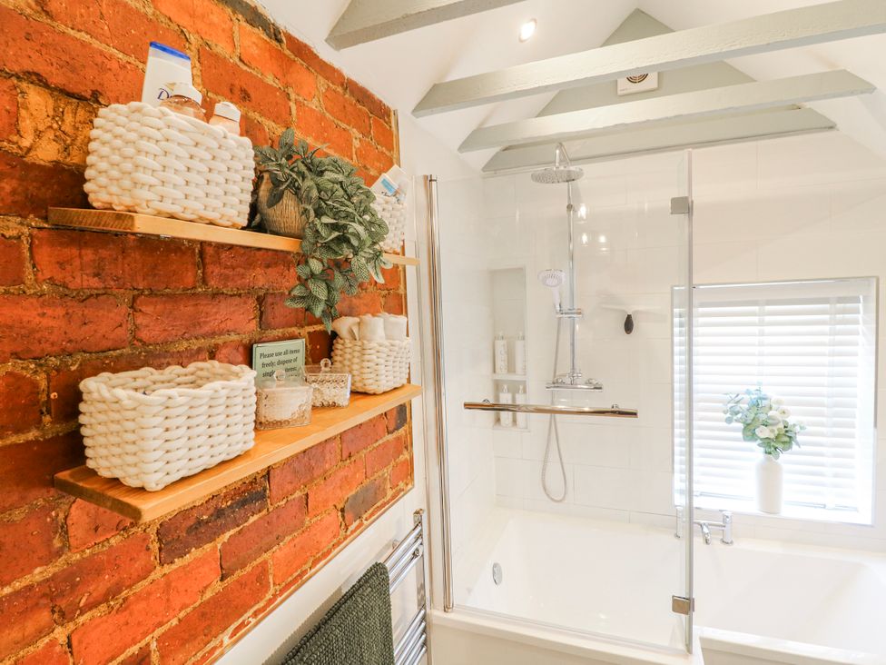 A bathroom with a shower and bathtub at Hill View Cottage Ashbourne