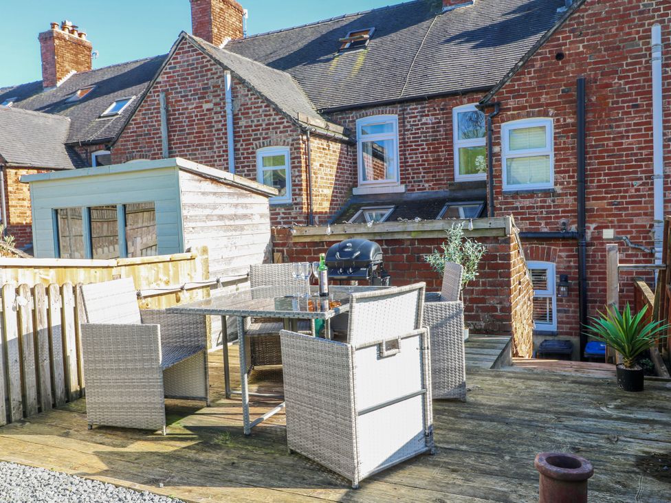 An outdoor patio with table and chairs at Hill View Cottage in Ashbourne