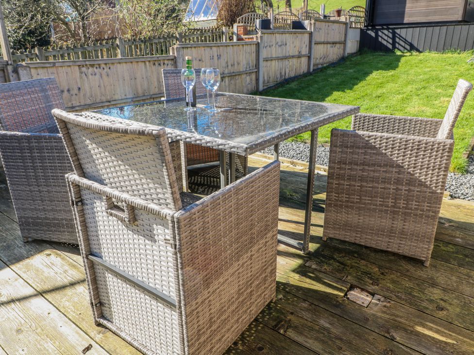 A table and chairs on a deck at Hill View Cottage Ashbourne