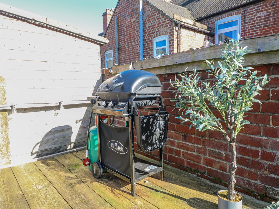 A grill and a plant on a deck at Hill View Cottage Ashbourne