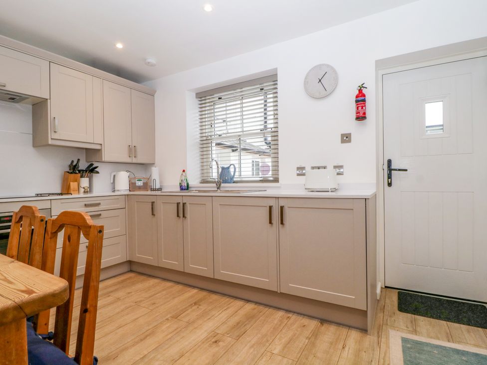 A kitchen with cabinets and appliances at Capella Cottage in Keswick