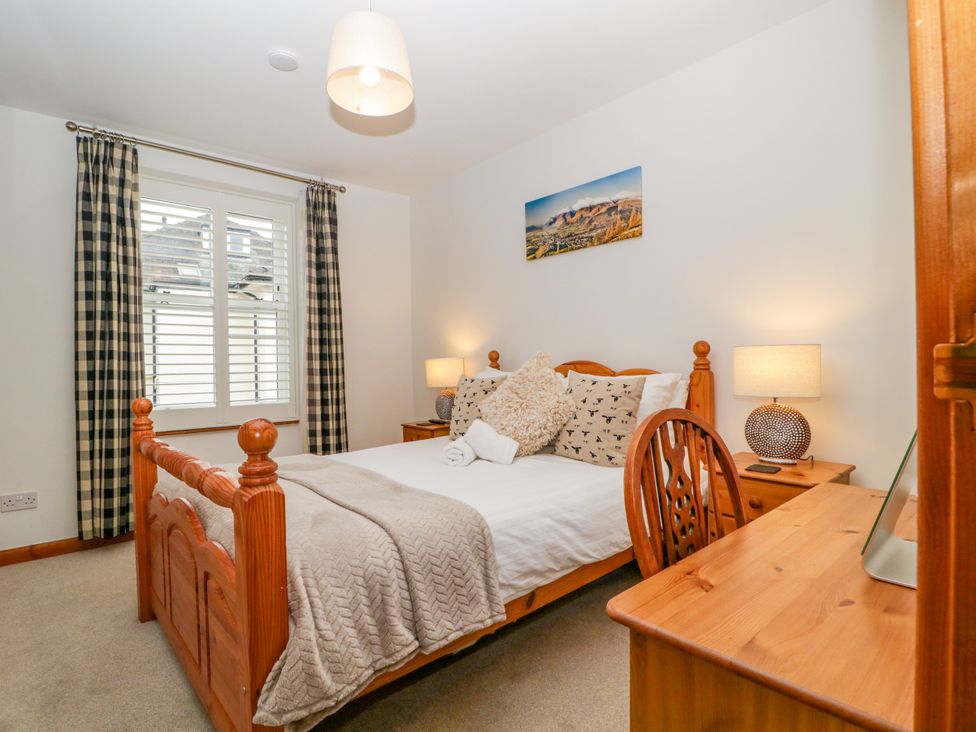 A bedroom with a bed and desk at Capella Cottage in Keswick