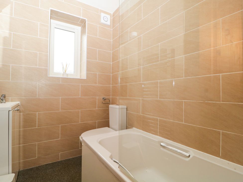 A bathroom with a bathtub, toilet, and sink at Capella Cottage in Keswick
