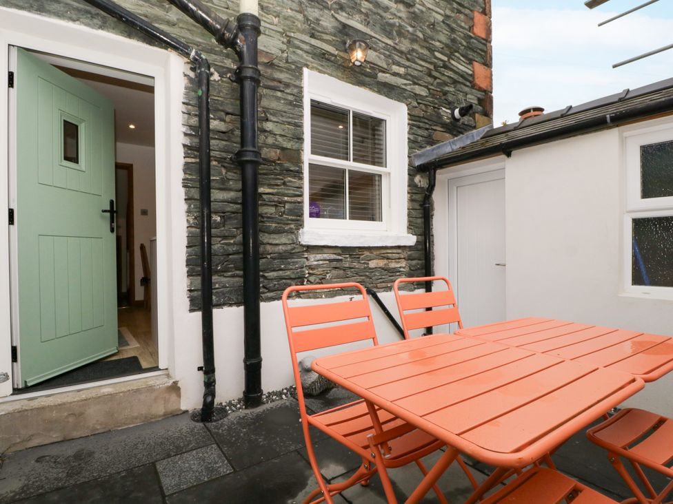 An outdoor seating area with a table and chairs at Capella Cottage in Keswick