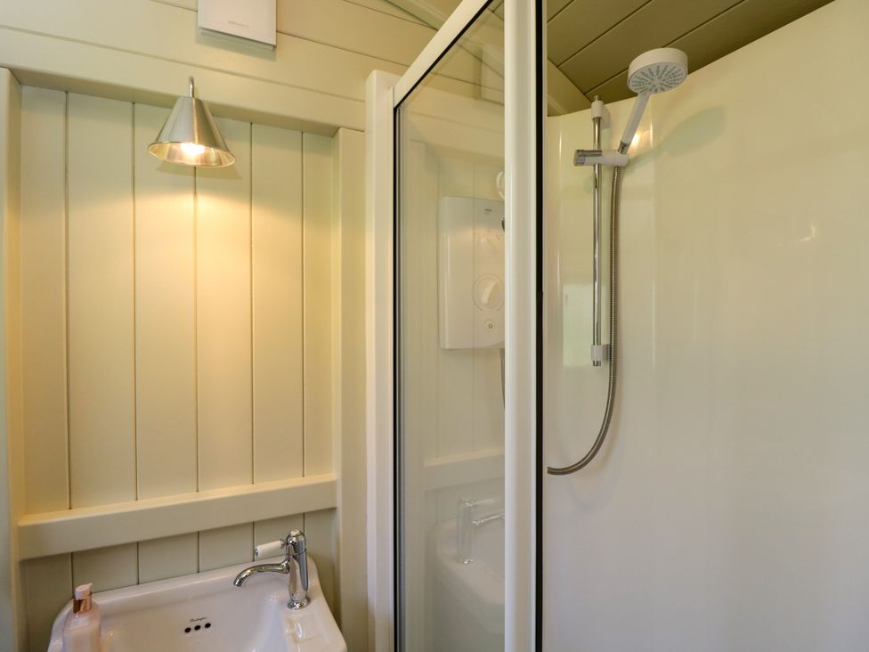 A bathroom with a sink and a shower with a handheld showerhead at Blackthorn in South Leigh near Witney