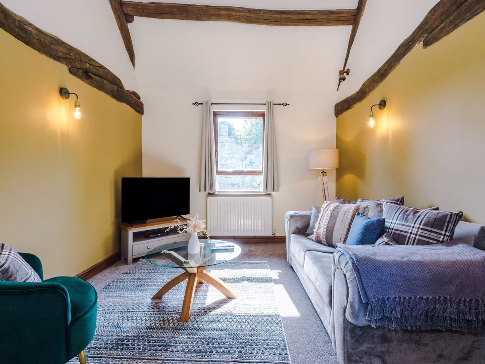 A living room with a television and coffee table at Idris Barn in Dolgellau