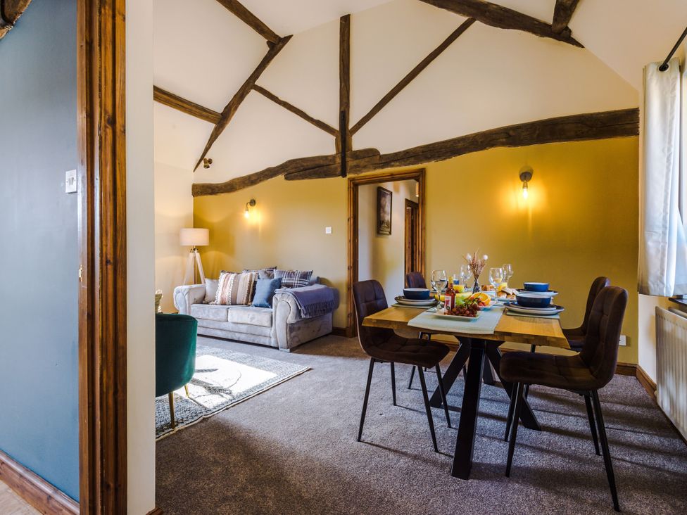 A living room with a sofa and dining area at Idris Barn Dolgellau