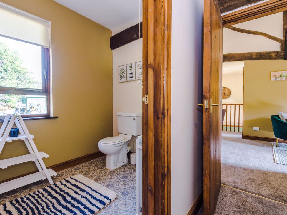 A bathroom with a toilet and window at Idris Barn Dolgellau