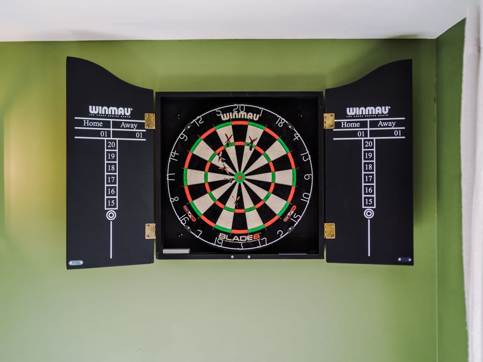 A dartboard mounted on a wall with a scoring board at Idris Barn Dolgellau