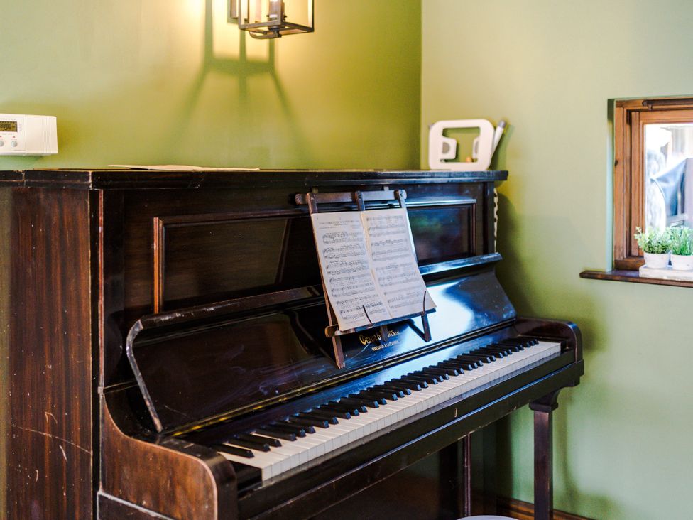 A piano with music sheet on top in a music room at Idris Barn Dolgellau