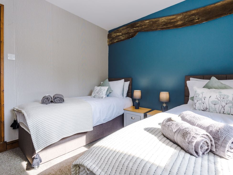 A bedroom with two single beds and a nightstand at Idris Barn Dolgellau