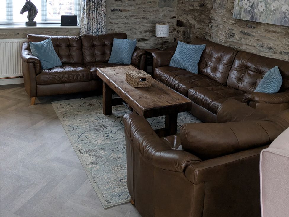 A living room with sofas and a coffee table at La Bastille in Maenclochog