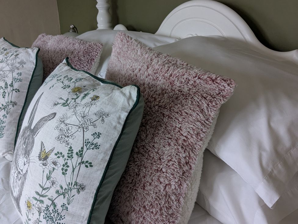 A bed with decorative pillows at La Bastille in Maenclochog