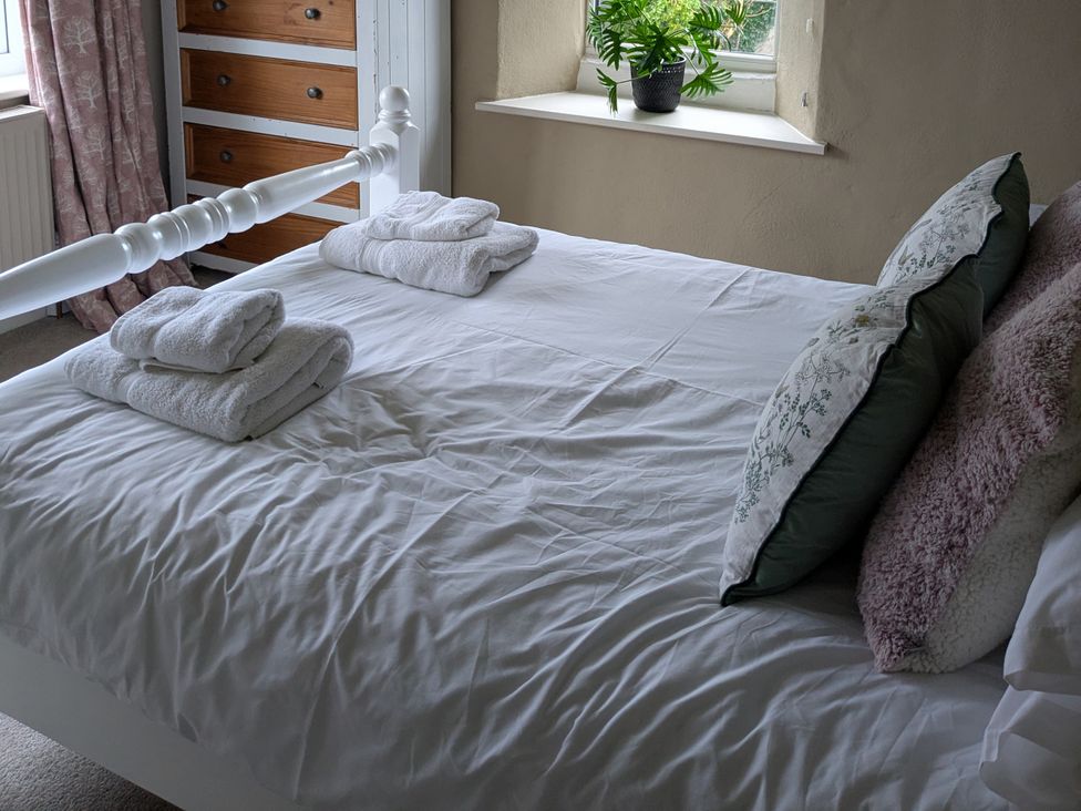 A bedroom with a bed and towels at La Bastille in Maenclochog