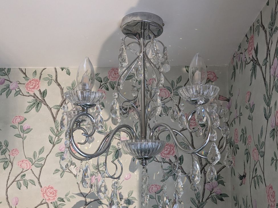 A chandelier with crystal elements in a room at La Bastille in Maenclochog