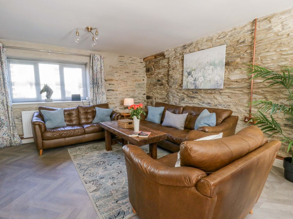 A living room with a sofa and a coffee table at La Bastille in Maenclochog