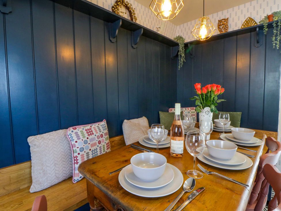 A dining room with a table set for a meal at La Bastille in Maenclochog