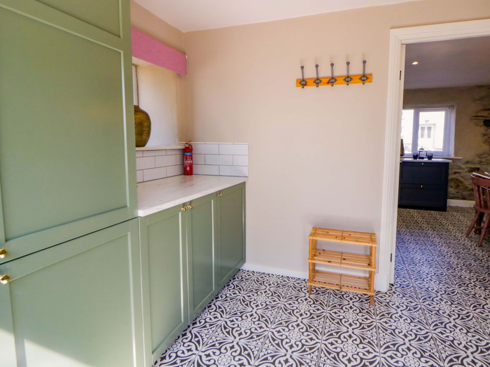 A kitchen with green cabinets and countertop at La Bastille in Maenclochog