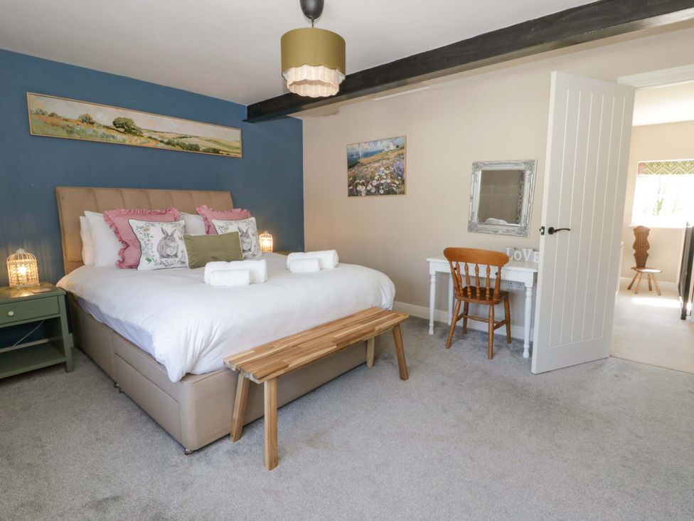 A bedroom with a bed, bedside table, and desk at La Bastille in Maenclochog